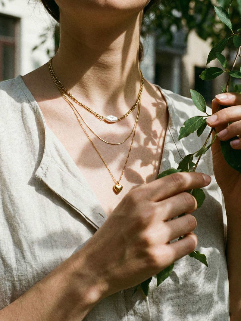3er-Kette Herzstueck Ambiente-Foto – goldene Layering-Kette mit Herzanhaenger elegant inszeniert