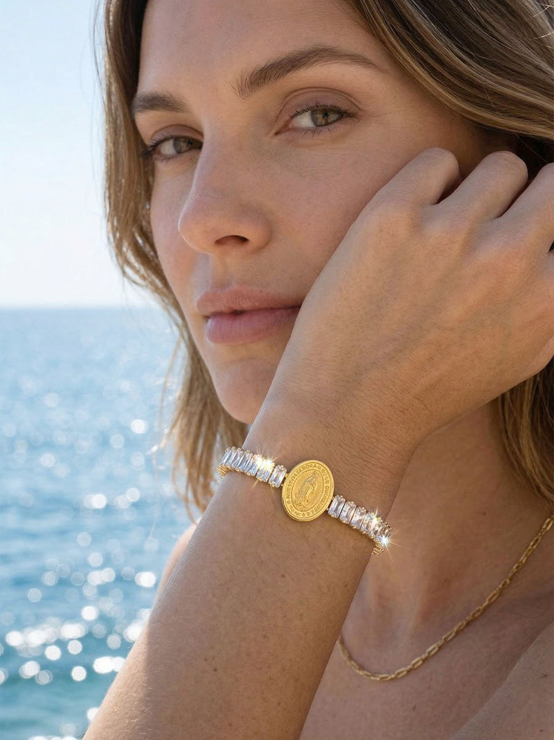 Armband Benedizione getragen – Model-Seitenprofil mit funkelndem Kristallarmband, Hand an der Wange, Meerblick