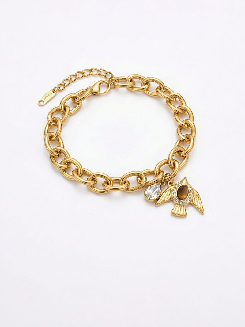 Armband Liberte Gold – Kraeftige Gliederkette mit goldenem Vogel-Anhaenger und Tigerauge-Cabochon, weisser Hintergrund