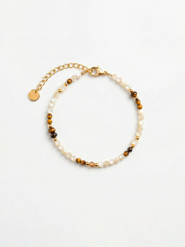 Armband Sahel – Handgefertigtes Armband mit Muschel-Perlen, Tigerauge und goldenen Akzenten, weisser Hintergrund