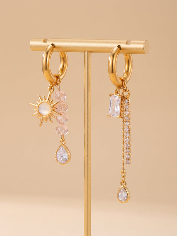 EH05C: Asymmetrische goldfarbene Creolen mit Sonne, rosa Perlen und klaren Tropfen am Schmuckständer.