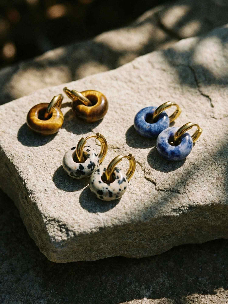 Himmelskreis Tiger Ohrringe Produktfoto – vergoldete Huggie-Ohrringe mit Tigerauge-Ring auf weissem Hintergrund