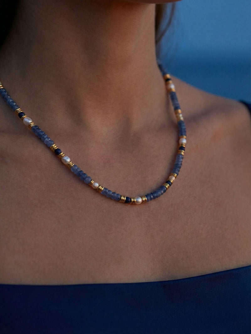 Ocean Night Kette am Dekollete getragen - Sodalith Perlen mit goldenem Glanz im warmen Abendlicht