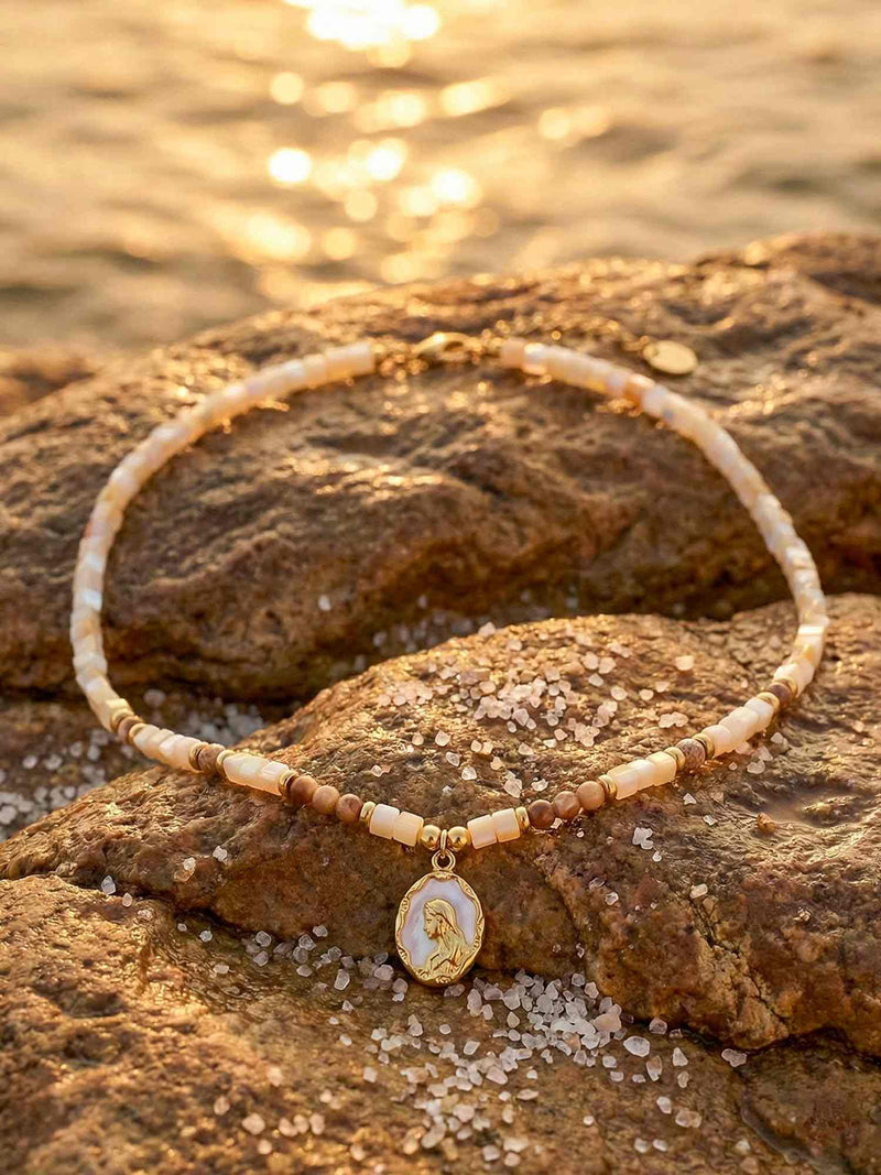 Frau trägt Ocean Muse Kette im Meer – Nemomatheo Boho-Halskette mit Meerjungfrauen-Anhänger bei Sonnenuntergang