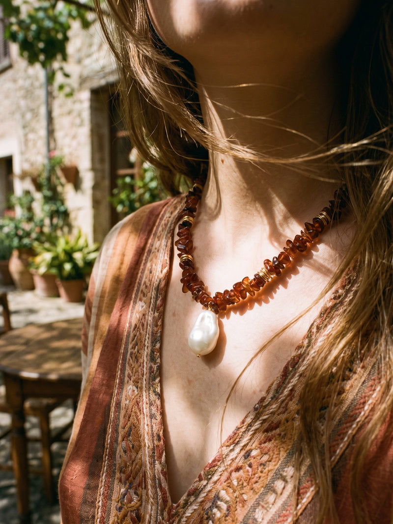 Vulkanblüte necklace in warm sunlight, worn with a patterned blouse