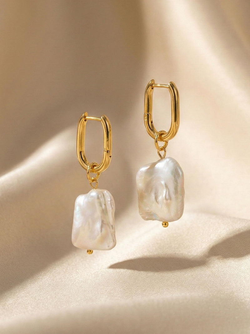 Marea Ohrringe auf beigem Satin – Goldene Huggie Hoops mit Barockperlen Flatlay elegante Produktfotografie