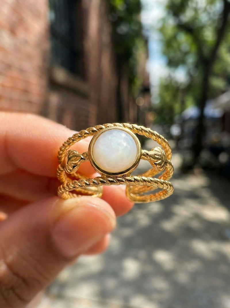 Ocean Twist Ring Nahaufnahme Perlmutt Stein in der Hand natuerliches Sonnenlicht Nemomatheo