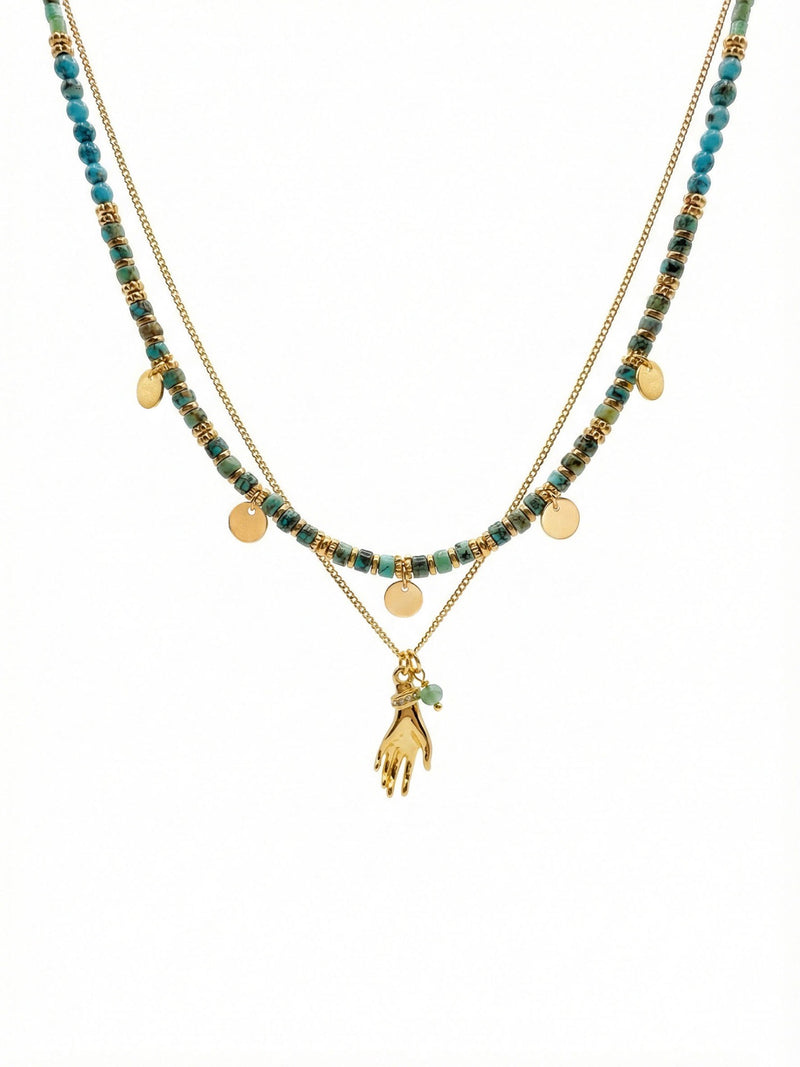 Quiet Protection Türkis Layering Halsketten-Set mit afrikanischen Türkis-Perlen goldenen Münz-Charms und 18K vergoldetem Hand-Anhänger auf weißem Hintergrund