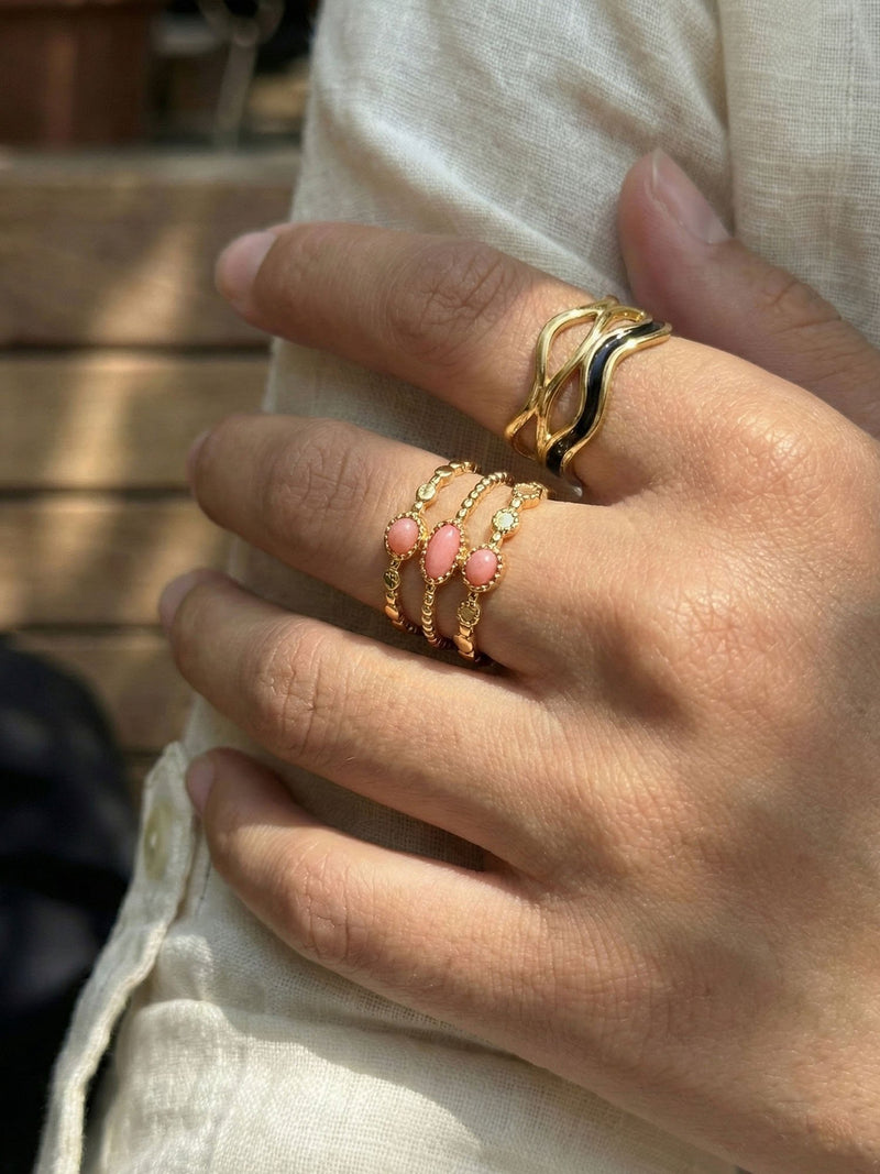 Ring Schichttraeume am Finger getragen Nahaufnahme drei rosa Steine goldener Ring Nemomatheo