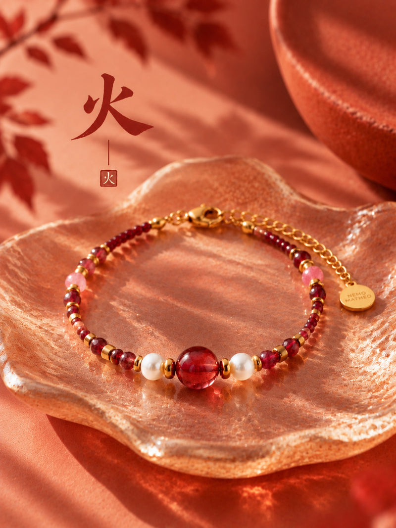 SL63C: Armband Cinque Elementi Feuer mit roten Perlen, als Stillleben mit dem chinesischen Elementzeichen.