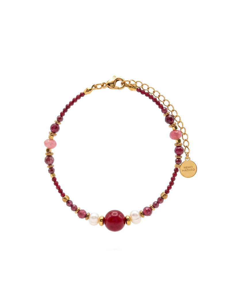 SL63C: Armband Cinque Elementi Feuer mit roten Perlen und goldfarbenen Details auf weißem Hintergrund.