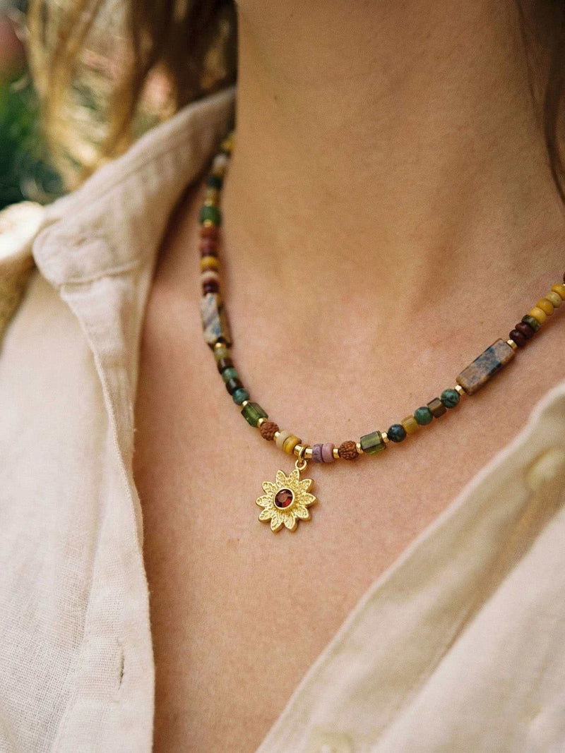 Kette Sonnenblume Totem – Detailaufnahme am Hals getragen, Nahaufnahme Anhaenger und Perlen