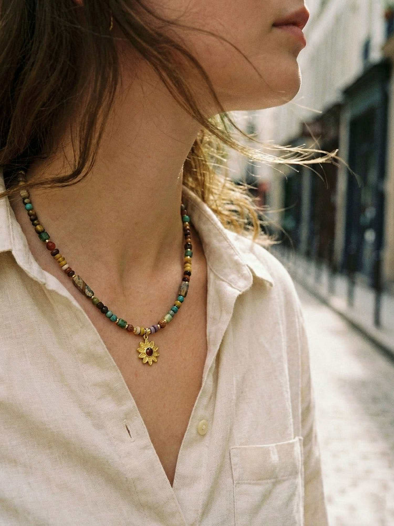 Kette Sonnenblume Totem – Detailaufnahme am Hals getragen, Nahaufnahme Anhaenger und Perlen