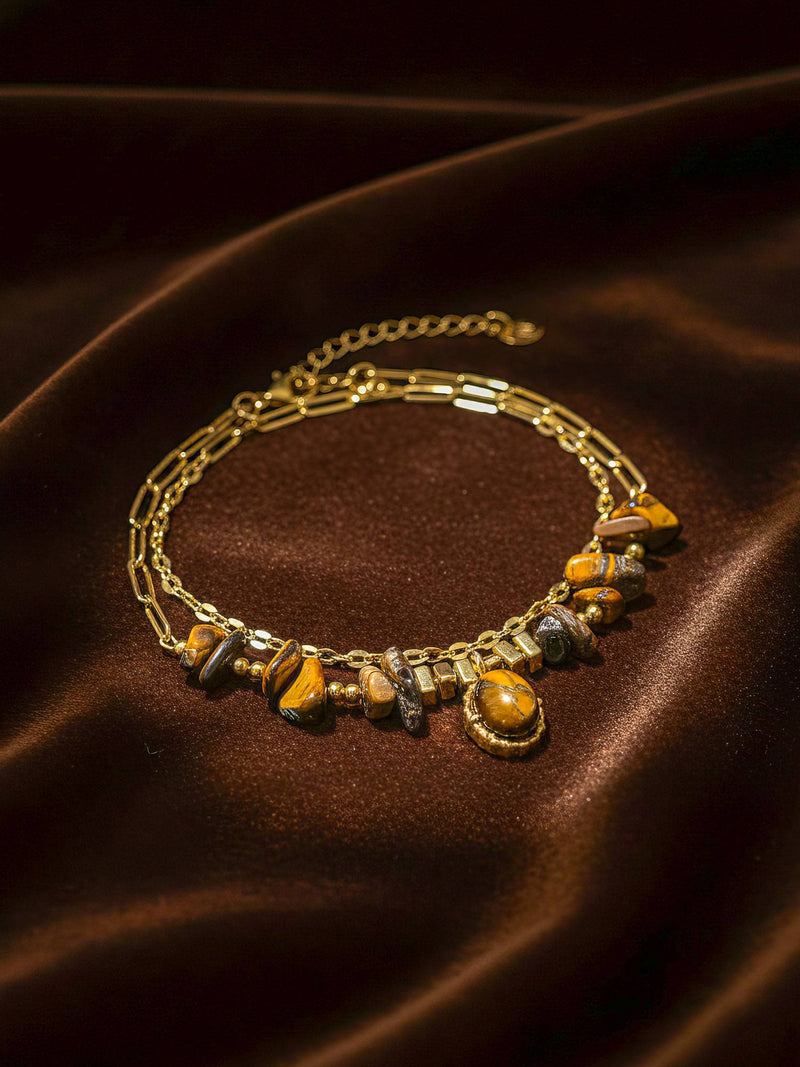 Stein und Glanz Armband Flatlay – Handgefertigtes Tigerauge-Armband mit Naturstein-Anhaenger auf braunem Samt 18K vergoldet