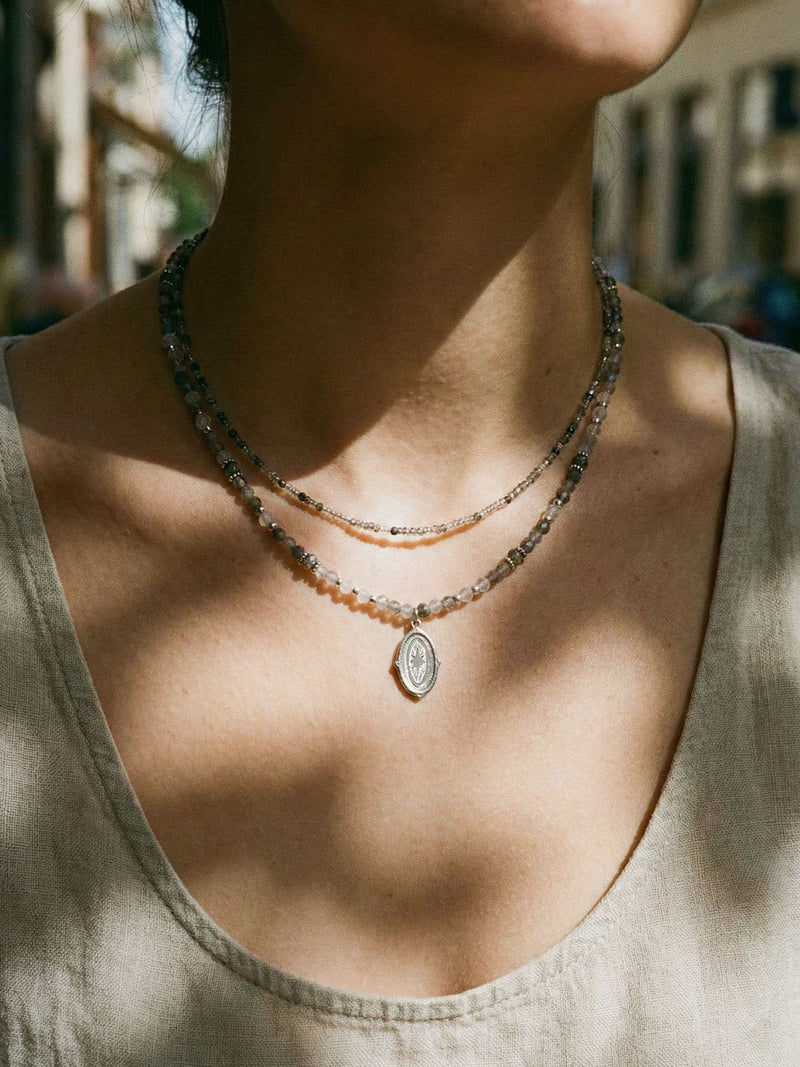 Kette Stern Oval Anhaenger – Detailaufnahme am Hals getragen, Nahaufnahme Anhaenger und Perlen