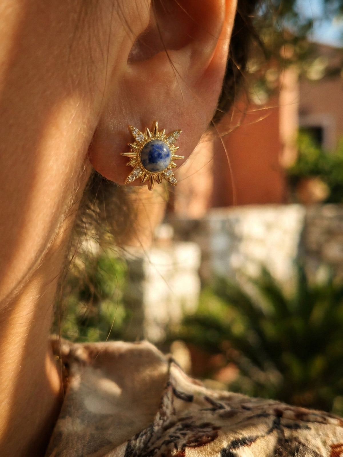 Soleil Azur Sonnen-Ohrstecker mit blauem Zentrum am Ohr getragen