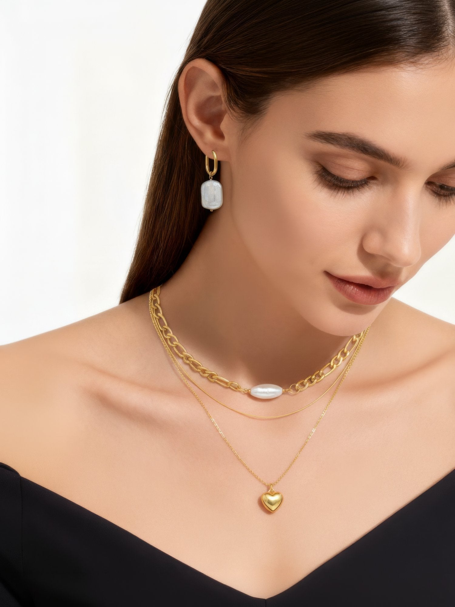 Goldene Creolen mit unregelmäßig geformten Süßwasserperlen, elegant auf hellem Sand platziert – natürlicher, minimalistischer Schmuck-Look.