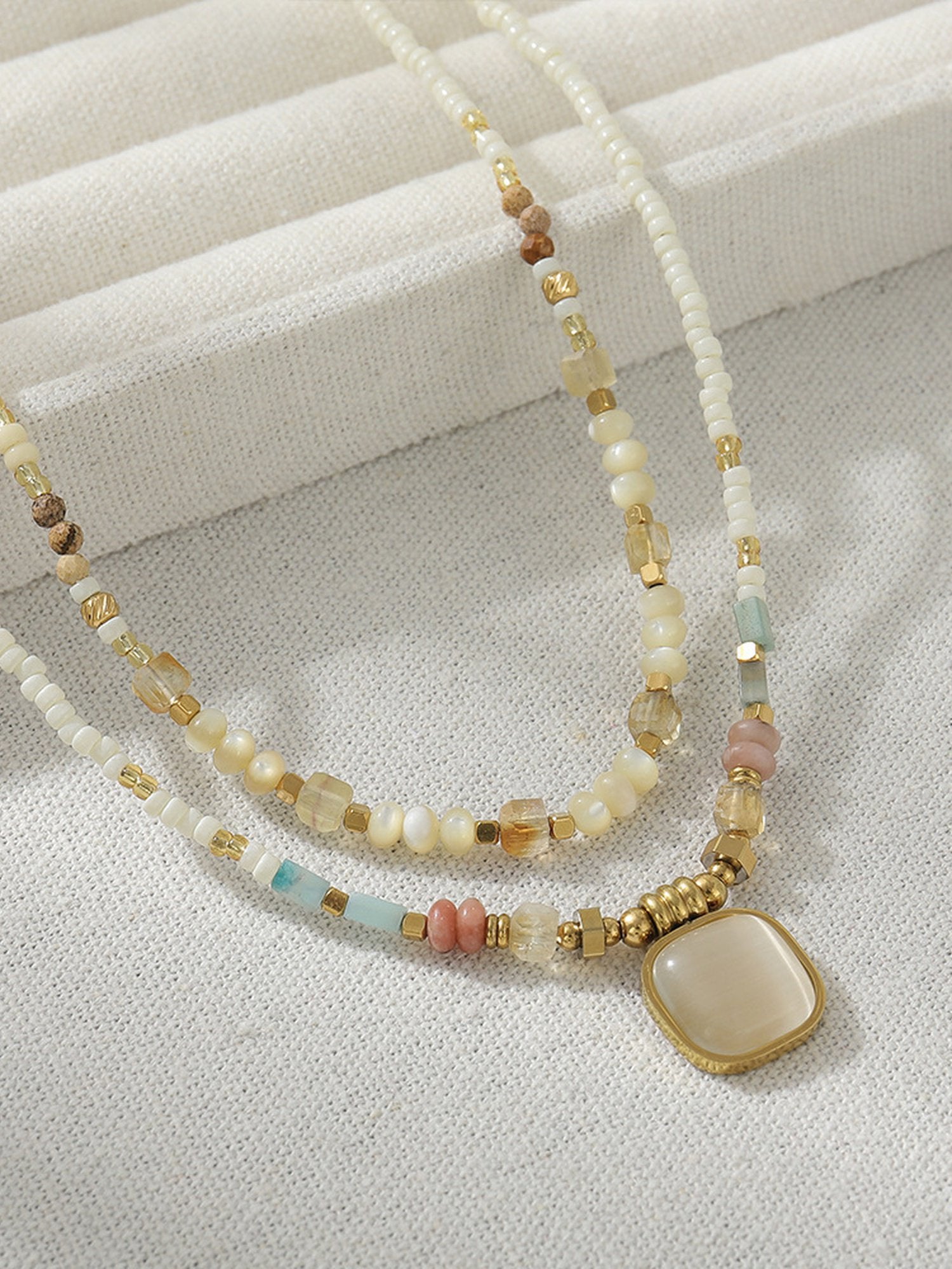 Detailaufnahme Naturstein-Anhänger – handgefasster Edelstein an Süßwasserperlenkette Sonnenglanz Design