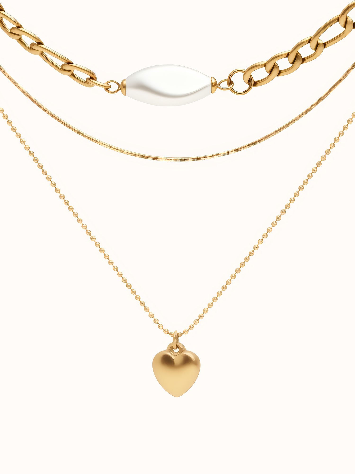 3-teilige goldene Halskette mit Herzanhänger - Vergoldete Layering-Kette mit weißer Perle und goldenem Herz auf weißem Hintergrund