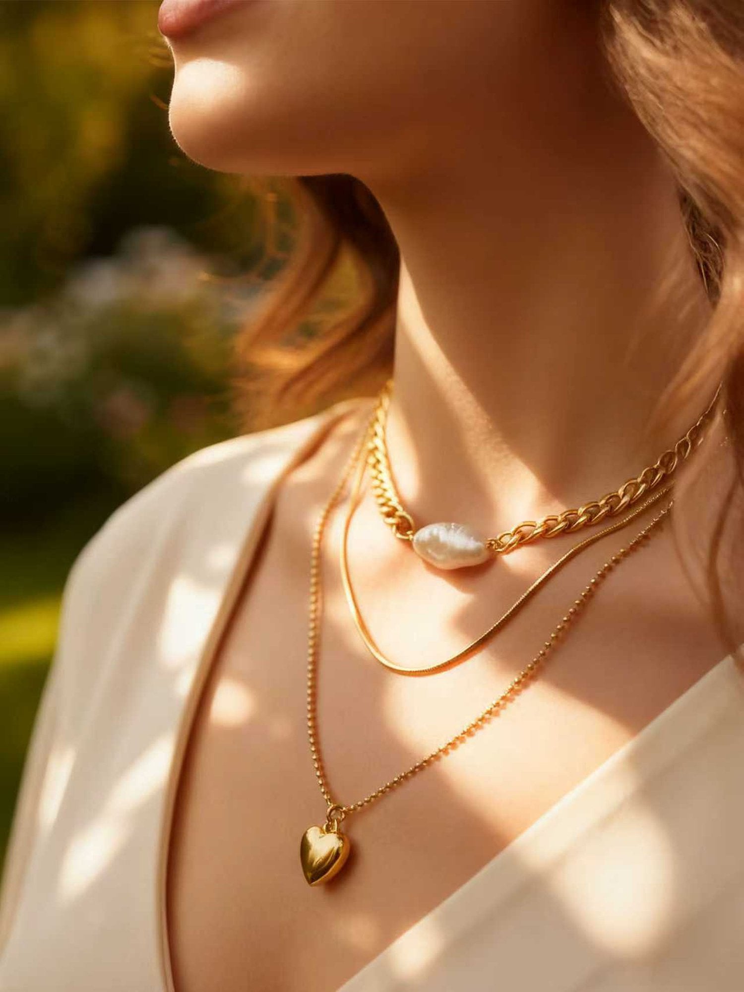 Dreifach-Layering-Halskette Herzstück mit Panzerkette und Perlendetail - 18K vergoldete Statement-Kette im natürlichen Licht getragen