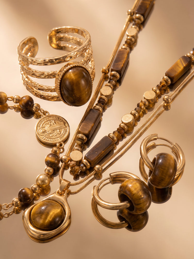 Nahaufnahme des Tigerauge-Schmucksets mit braunen und goldfarbenen Details – Anima in Fiore