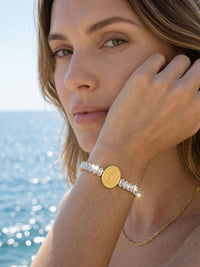Armband Benedizione getragen – Model-Seitenprofil mit funkelndem Kristallarmband, Hand an der Wange, Meerblick
