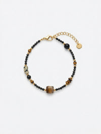 Armband Eclipse – Handgefertigtes Armband mit Tigerauge, schwarzem Obsidian und tibetischer Dzi-Perle, weisser Hintergrund