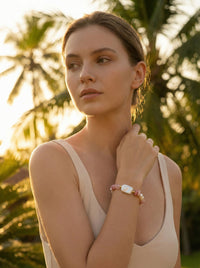 Junge Frau trägt Rosengarten Armband im tropischen Garten mit Rose - Natürlicher Boho Lifestyle Schmuck