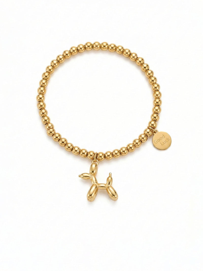 Armband Glueckshund – Goldenes Perlenarmband mit Ballonhund-Anhaenger und Good-Luck-Plaettchen, 18K vergoldet, weisser Hintergrund