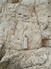Lifestyle-Foto Perlenarmband Elva Model in weißem Kleid vor weißen Felsen am Meer