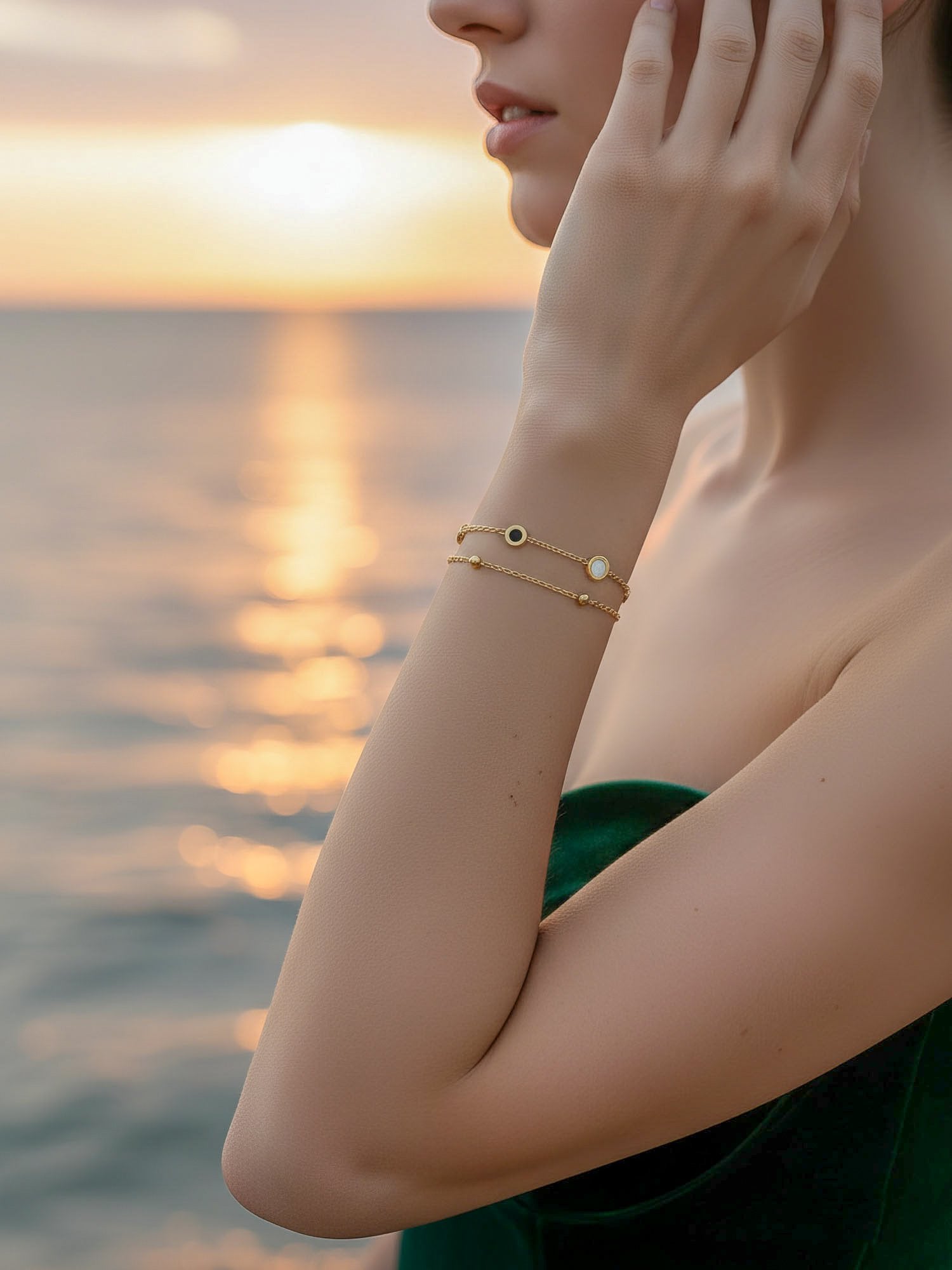Luna Dual Armband bei Sonnenuntergang am Meer - Vergoldetes Doppelarmband mit Emaille-Kreisen in romantischer Abendstimmung getragen