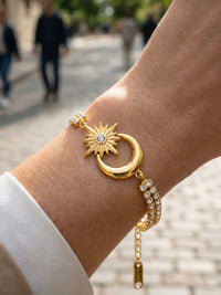 Armband Luna Sol am Handgelenk getragen – funkelnde Kristalle und goldenes Mond-Sonne-Motiv im Licht