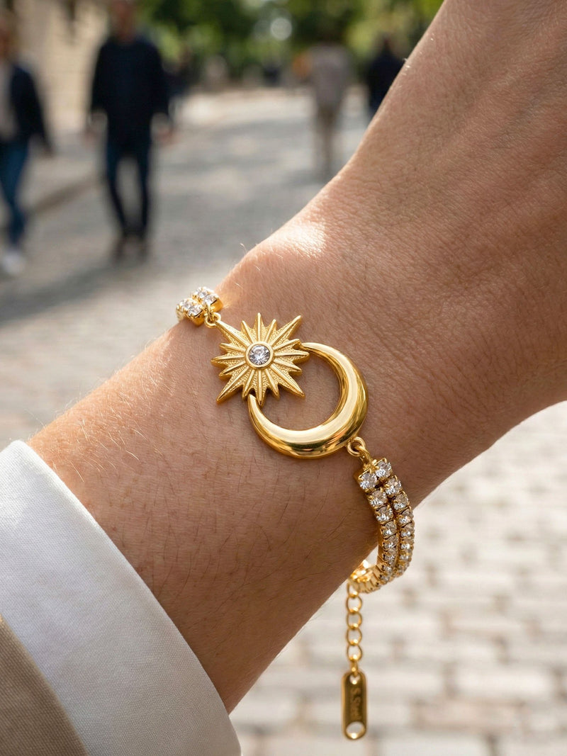 Armband Luna Sol am Handgelenk getragen – funkelnde Kristalle und goldenes Mond-Sonne-Motiv im Licht