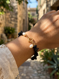 Nahaufnahme des goldfarbenen Ringverschlusses und der weißen Akzente am Armband Midnight Pearl
