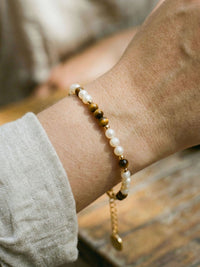 Armband Sahel Detailaufnahme – Nahaufnahme der natuerlichen Muschel-Perlen und Tigerauge-Steine