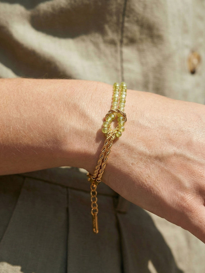 Armband Twist Olive am Handgelenk getragen – Nahaufnahme der olivgruenen Peridot-Perlen im natuerlichen Licht