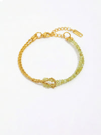 Armband Twist Olive – Doppellagiges Armband mit Peridot-Perlen und goldener Kordelkette, 18K vergoldet, weisser Hintergrund