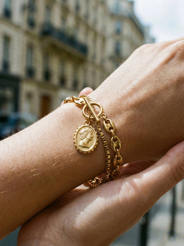Armband Victoria am Handgelenk getragen – goldenes Kamee-Armband mit klassischem Damenportrait im Sonnenlicht