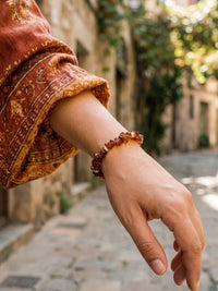 Nahaufnahme des Armbands Vulkanblüte am Handgelenk in einer sonnigen Gasse