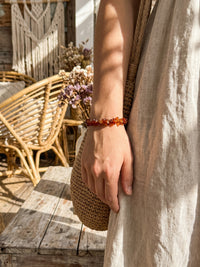 Armband Vulkanblüte, getragen neben einer geflochtenen Tasche