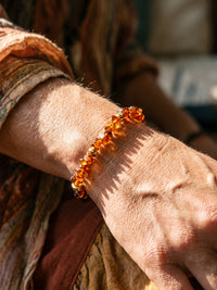 Makroaufnahme der rotbraunen Splitter am Armband Vulkanblüte auf dem Handgelenk