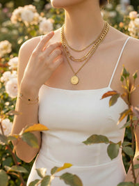 Model traegt Aurelia Muenzkette und Armband im weissen Traegerkleid zwischen weissen Rosen romantisch