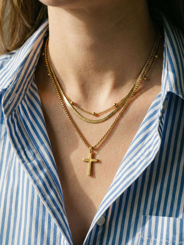 Devotion Kette getragen – Model traegt elegante Kreuz-Kette mit mehreren Kettenreihen
