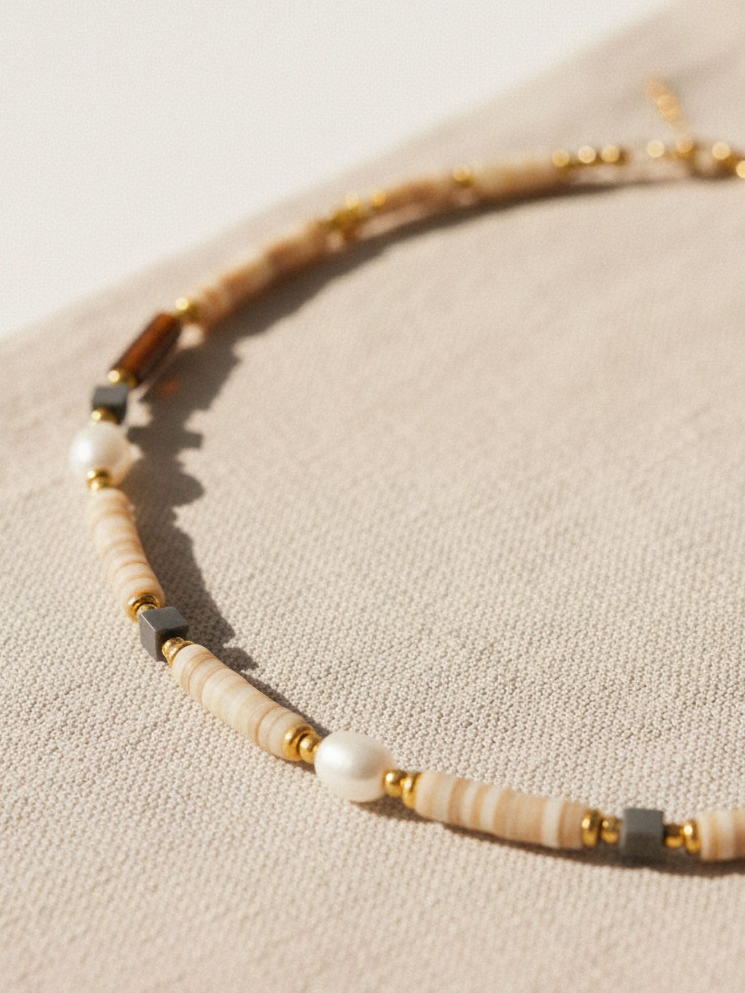 Nahaufnahme Earthlines Perlenkette - Handgefädelte Heishi-Perlen in warmen Braun- und Beigetönen mit Süßwasserperlen