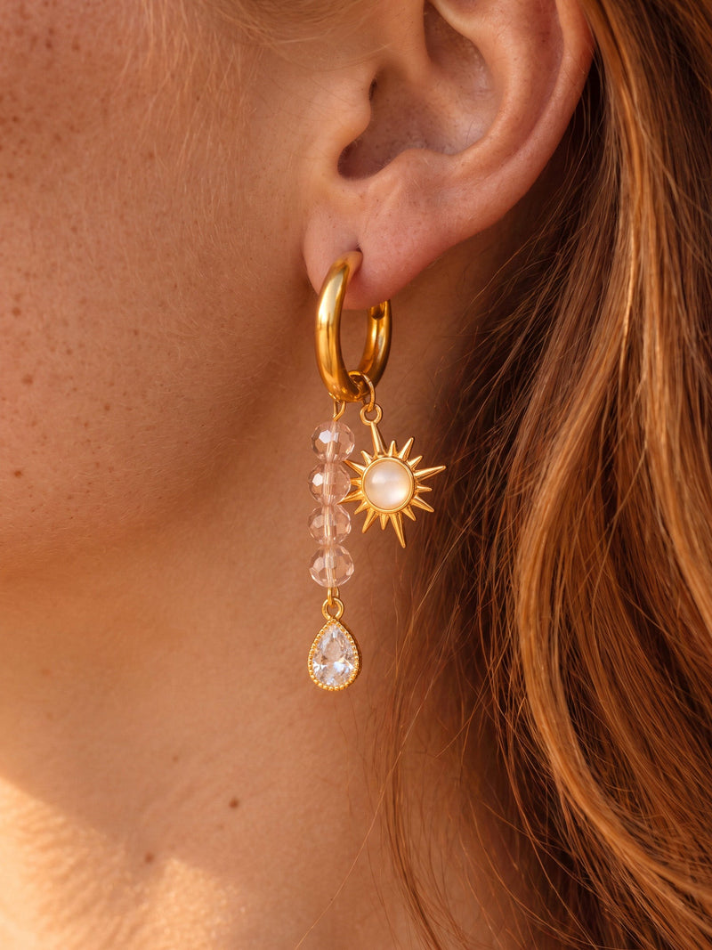 EH05C: Nahaufnahme der goldfarbenen Creole mit Sonne, rosa Perlenstrang und Tropfenanhänger.