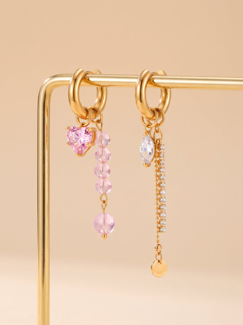 EH05D: Beide asymmetrischen Creolen mit rosa Herz und Kettenseite an einem goldfarbenen Ständer.