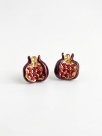 EH53: Rote Granatapfel-Ohrstecker mit goldfarbenen Konturen, auf hellem Untergrund stehend.
