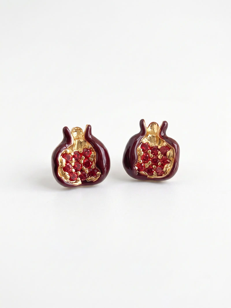 EH53: Rote Granatapfel-Ohrstecker mit goldfarbenen Konturen, auf hellem Untergrund stehend.