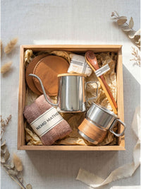 Geschenkbox Lebensart Meisterwerk Produktbild Naturholzbox mit Handbruehkanne Becher Lederuntersetzer und Holzloeffel
