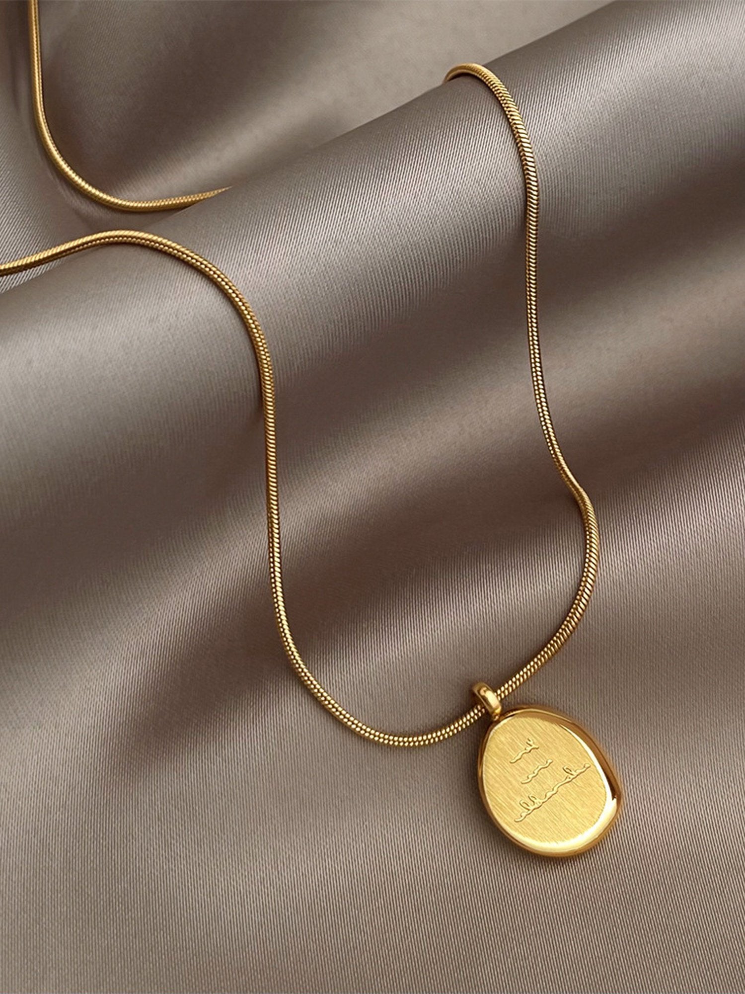 Frau trägt zarte Perlenkette Adorable mit Gravur-Anhänger – elegante Everyday-Halskette in Goldfilled mit natürlichen Süßwasserperlen